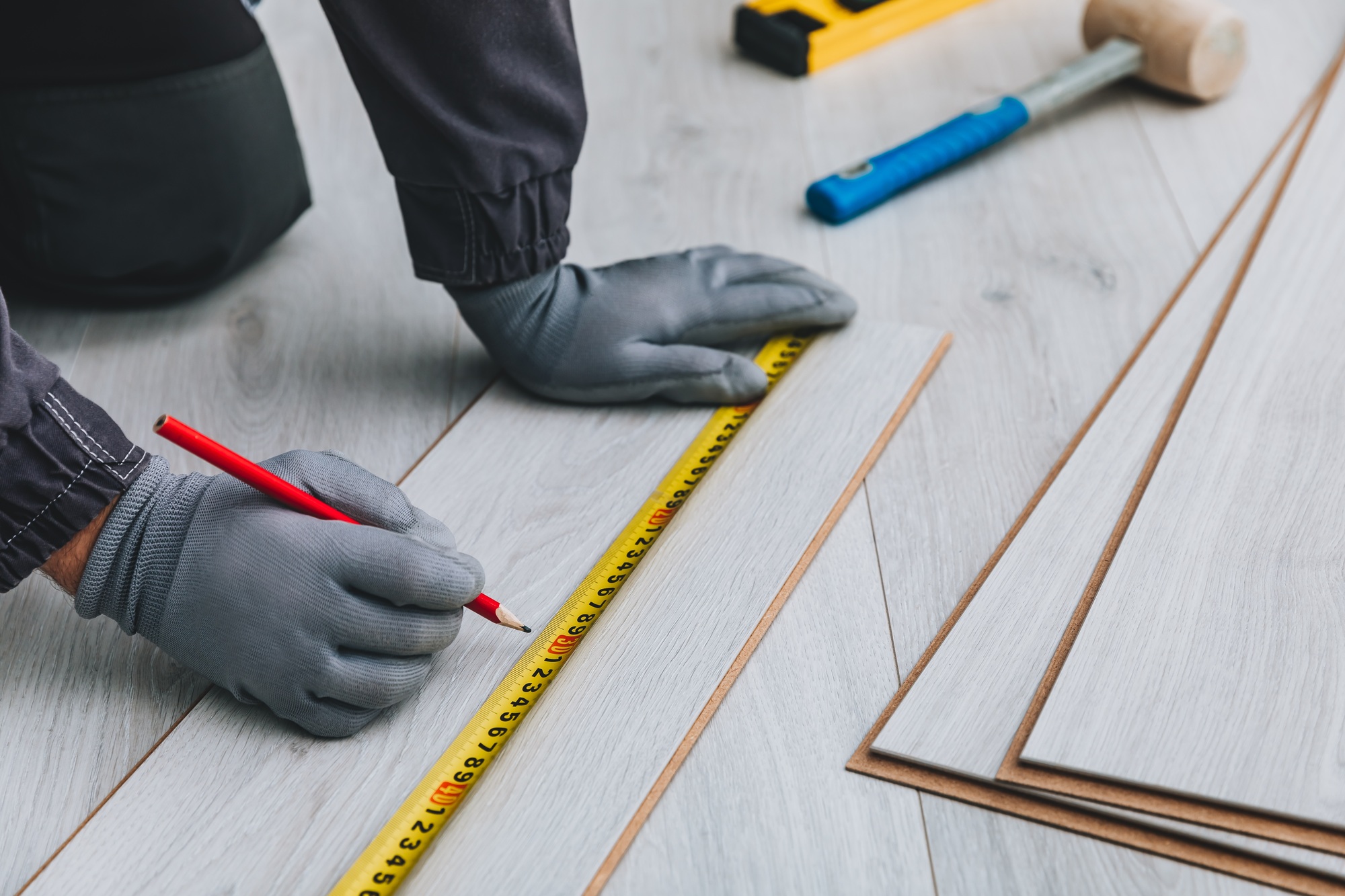 Worker installing new laminated wooden floor